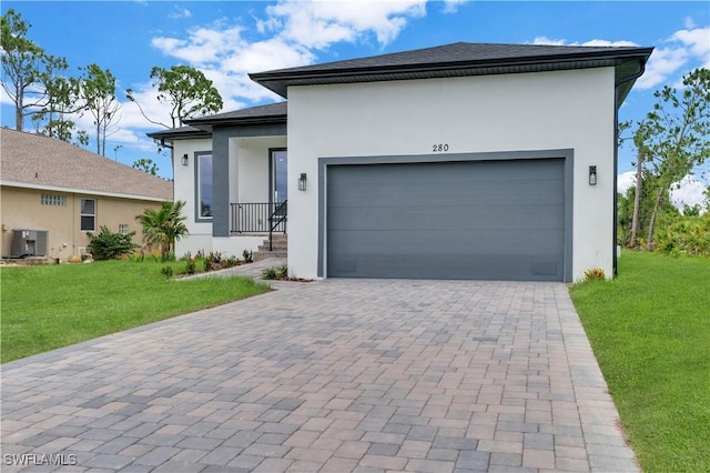 view of front of house with a front yard, central AC, and a garage