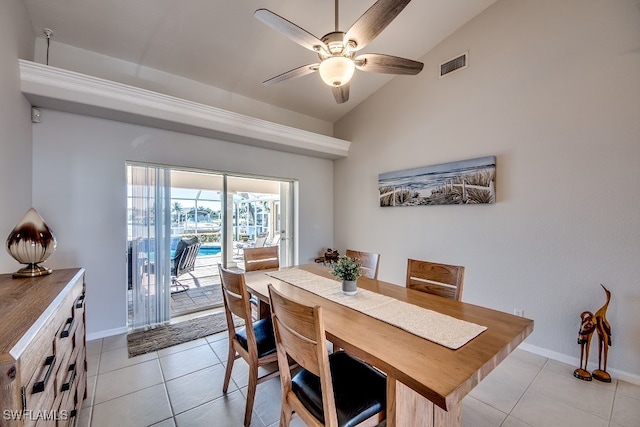 tiled dining area featuring ceiling fan and vaulted ceiling