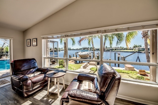 sunroom / solarium featuring a water view and lofted ceiling