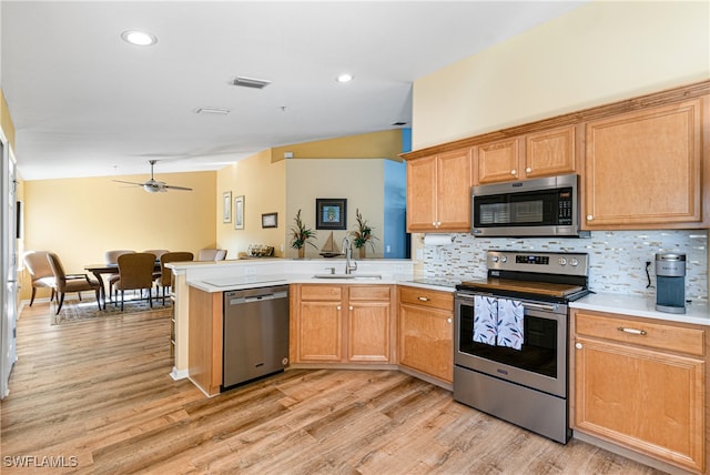 kitchen with decorative backsplash, sink, light wood-type flooring, and stainless steel appliances