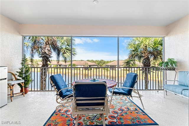 sunroom / solarium featuring a water view