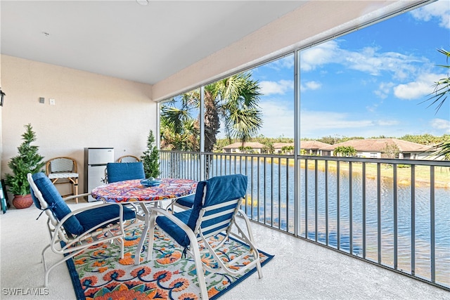 sunroom / solarium featuring a water view