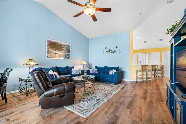 living room with hardwood / wood-style floors, high vaulted ceiling, and ceiling fan