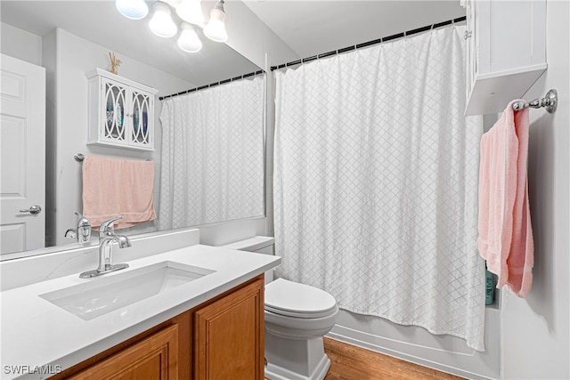 full bathroom featuring hardwood / wood-style flooring, vanity, toilet, and shower / tub combo with curtain