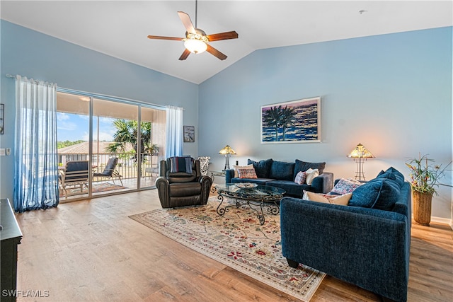 living room with hardwood / wood-style flooring, ceiling fan, and vaulted ceiling