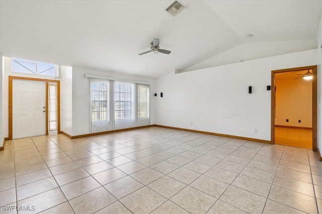 empty room with lofted ceiling, ceiling fan, and light tile patterned floors