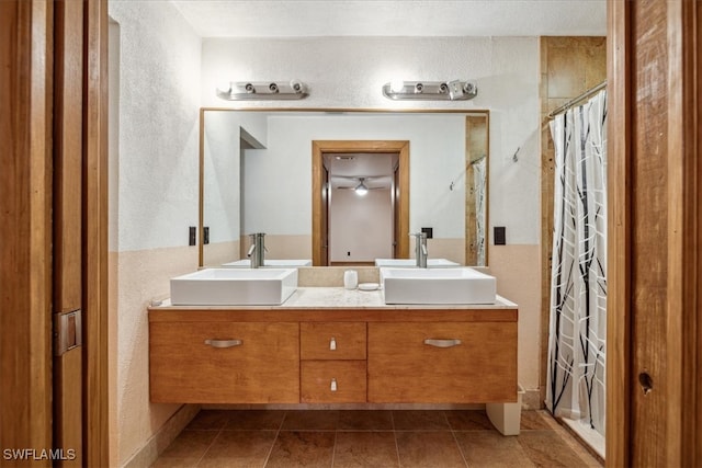 bathroom with tile patterned flooring, ceiling fan, curtained shower, and vanity