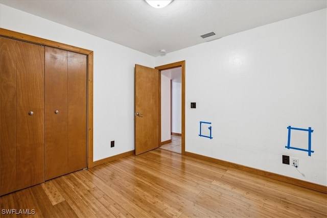 unfurnished bedroom featuring light hardwood / wood-style floors and a closet