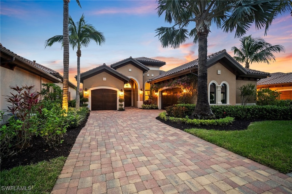 mediterranean / spanish house with a lawn and a garage