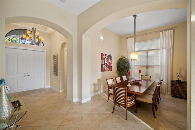 tiled dining area featuring an inviting chandelier