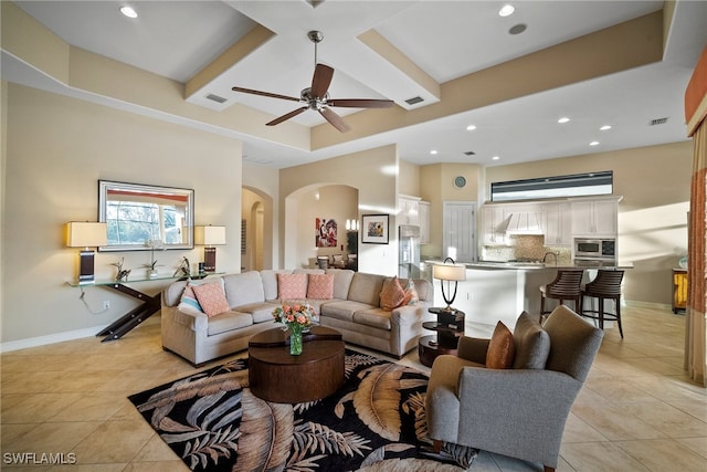 living room featuring ceiling fan, light tile patterned floors, and sink