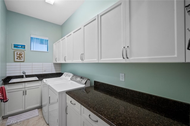 laundry area featuring cabinets, washing machine and clothes dryer, and sink