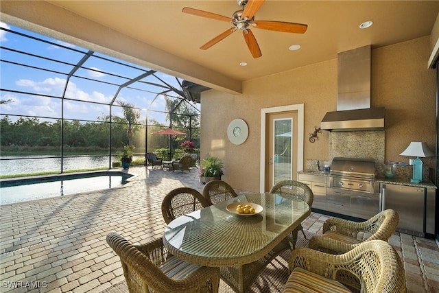 view of patio featuring a lanai, area for grilling, ceiling fan, and a water view