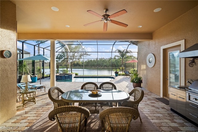 sunroom / solarium featuring a water view, ceiling fan, and a healthy amount of sunlight