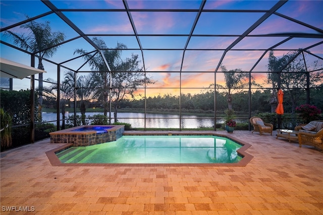 pool at dusk with an in ground hot tub, a lanai, a patio, and a water view