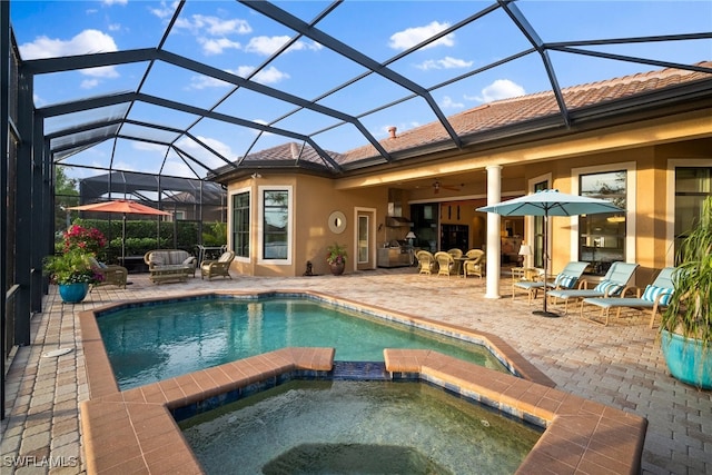 view of swimming pool featuring an in ground hot tub, a patio, ceiling fan, and a lanai