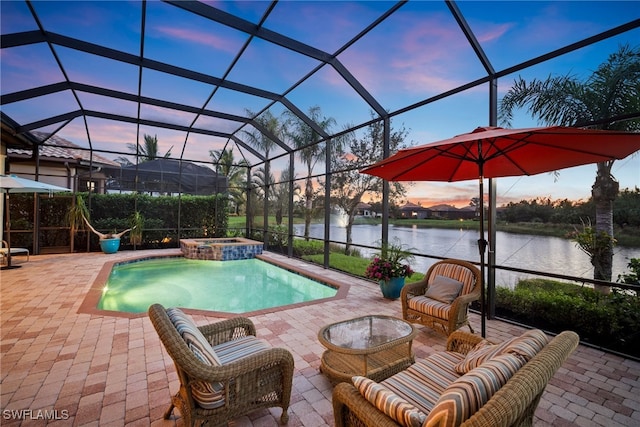 pool at dusk featuring an in ground hot tub, a patio, a water view, and a lanai