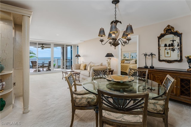 carpeted dining space with a notable chandelier, a water view, and expansive windows