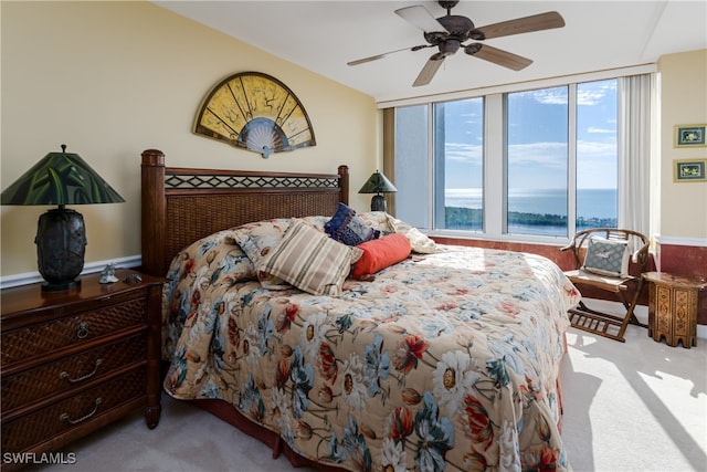 carpeted bedroom with ceiling fan and a water view