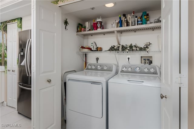 clothes washing area with light tile patterned floors and separate washer and dryer