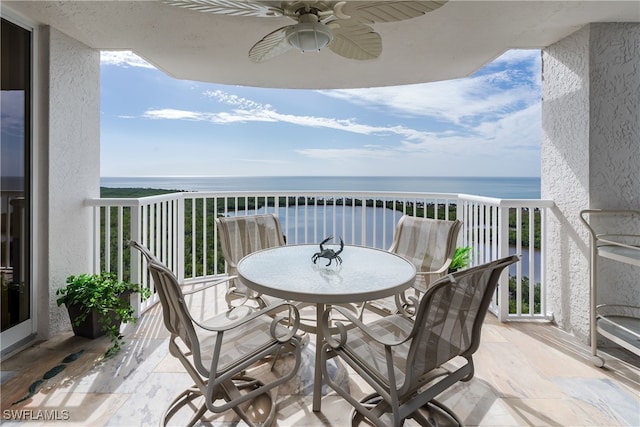 balcony with ceiling fan and a water view