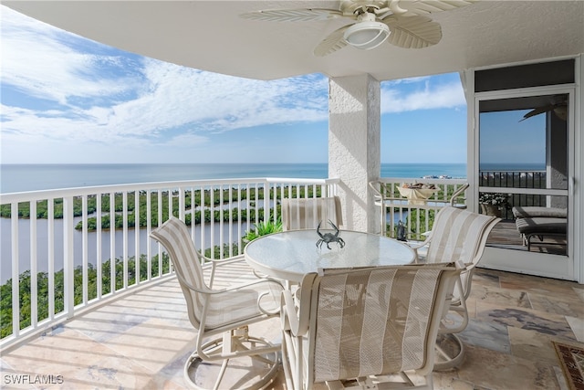 balcony with ceiling fan and a water view