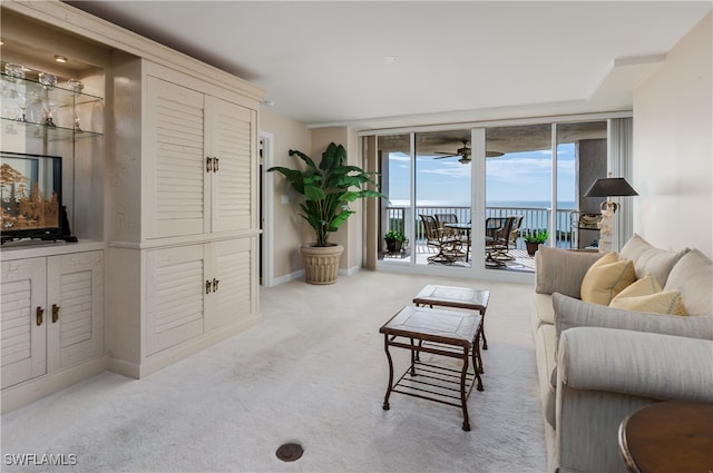 carpeted living room featuring a water view and expansive windows