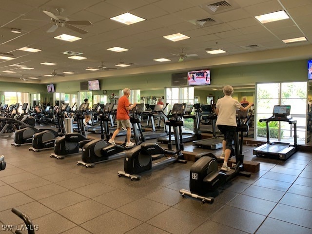 exercise room with ceiling fan and a paneled ceiling