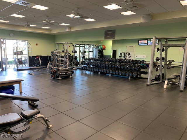 workout area with a drop ceiling and ceiling fan