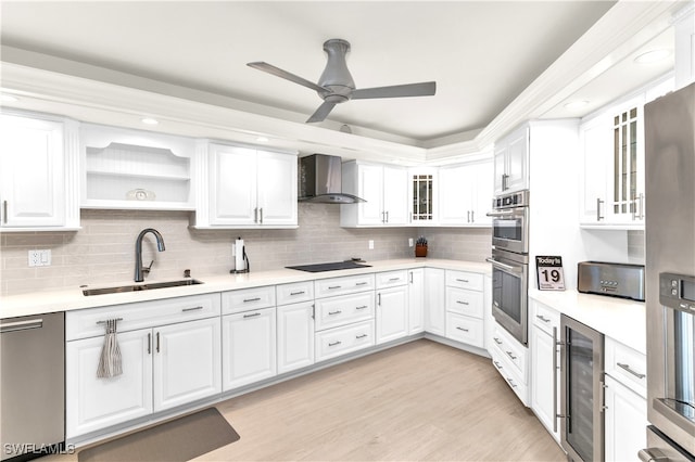 kitchen featuring wall chimney range hood, sink, wine cooler, tasteful backsplash, and white cabinetry