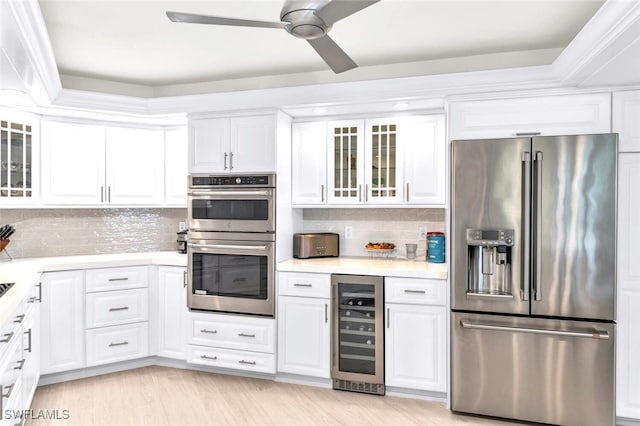 kitchen featuring white cabinetry, stainless steel appliances, and beverage cooler