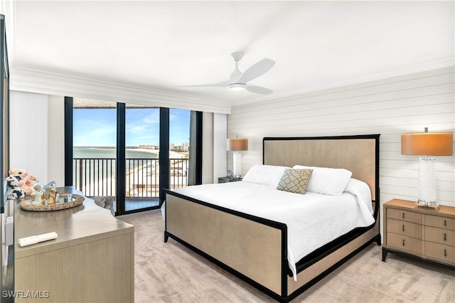 bedroom with ceiling fan, light colored carpet, access to outside, wooden walls, and a water view