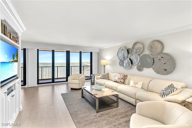 living room with hardwood / wood-style flooring, expansive windows, a water view, and crown molding