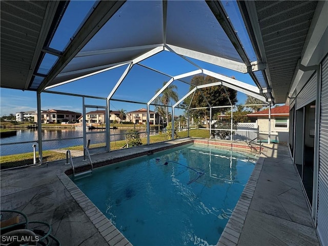 view of swimming pool featuring a patio, glass enclosure, and a water view