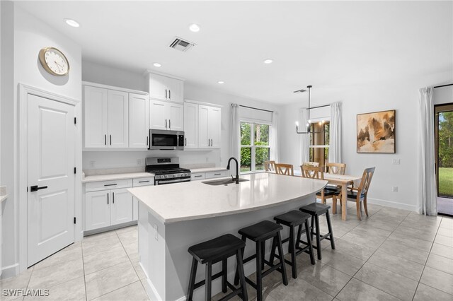 kitchen featuring plenty of natural light, white cabinetry, sink, and appliances with stainless steel finishes