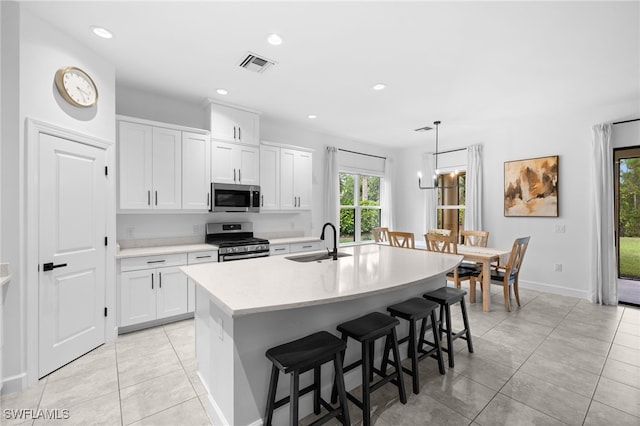 kitchen featuring white cabinetry, appliances with stainless steel finishes, sink, and a center island with sink