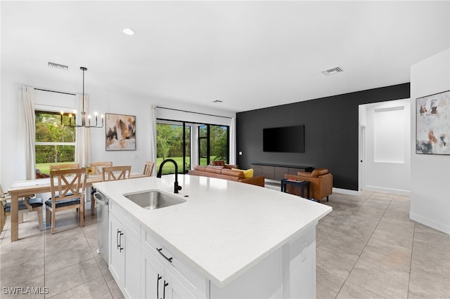 kitchen with pendant lighting, a center island with sink, white cabinetry, and sink