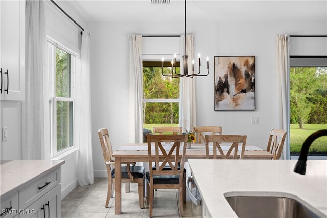 tiled dining area with sink and a notable chandelier