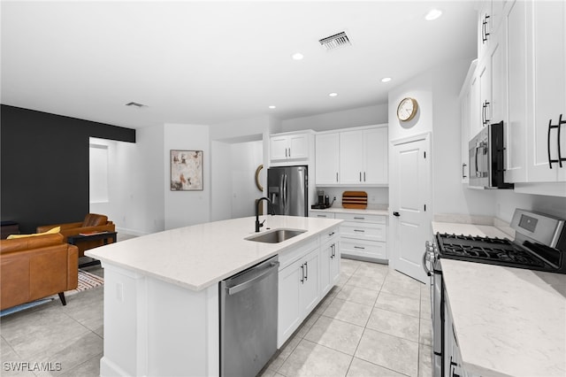 kitchen featuring stainless steel appliances, white cabinetry, sink, and a center island with sink