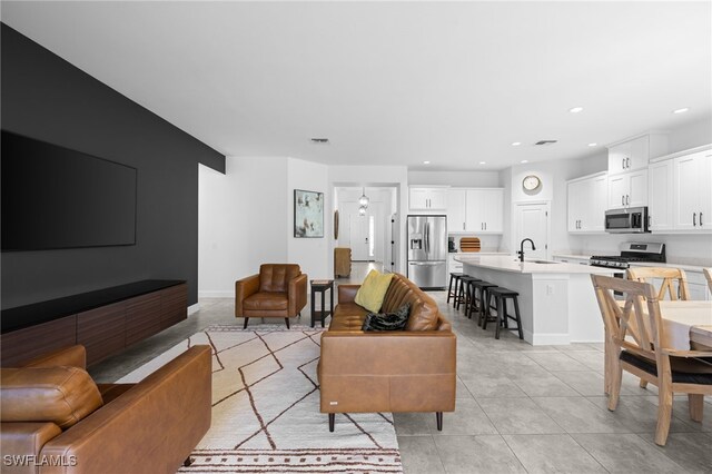 living room featuring sink and light tile patterned floors