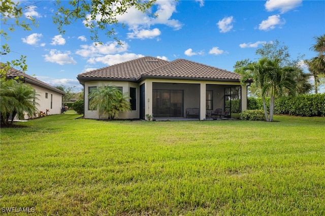 rear view of property with a lawn and a sunroom