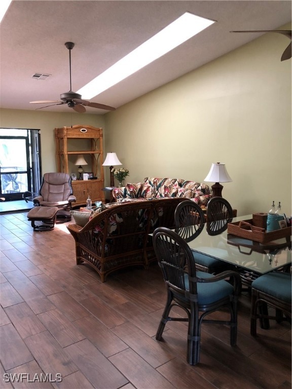 dining space featuring a skylight, hardwood / wood-style flooring, and ceiling fan