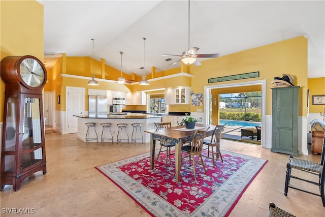 dining room with ceiling fan, sink, and high vaulted ceiling