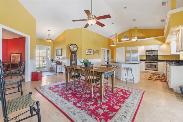 dining area with ceiling fan, light tile patterned floors, and high vaulted ceiling