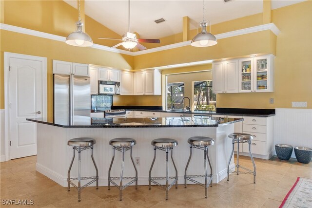 kitchen featuring a breakfast bar, stainless steel fridge, white cabinetry, and range with electric stovetop