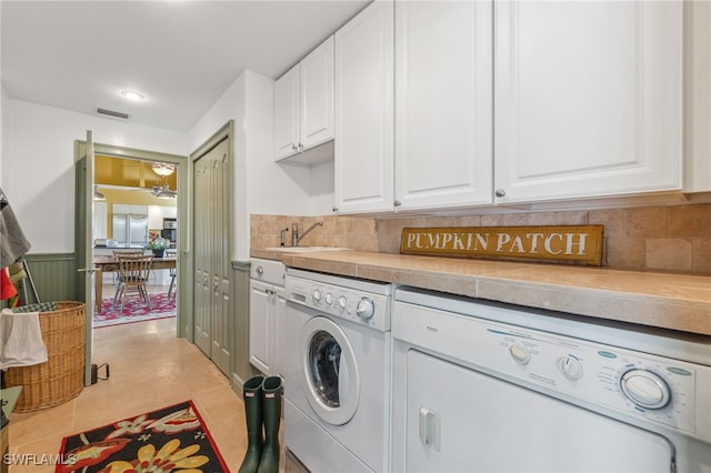 laundry area with washer and dryer, light tile patterned floors, cabinets, and sink