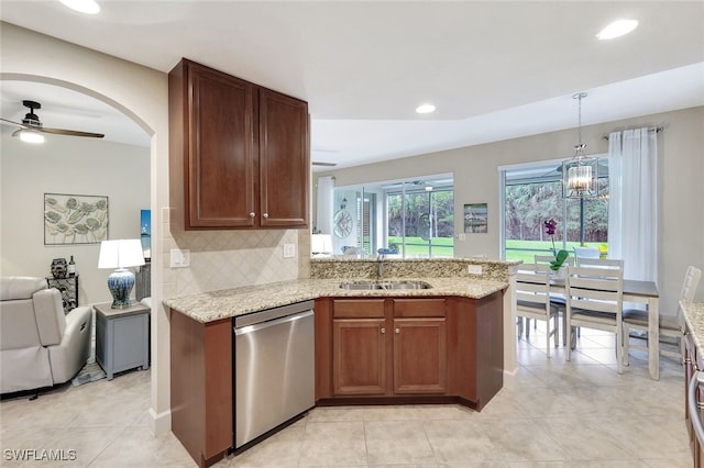 kitchen with dishwasher, ceiling fan with notable chandelier, hanging light fixtures, sink, and light stone countertops