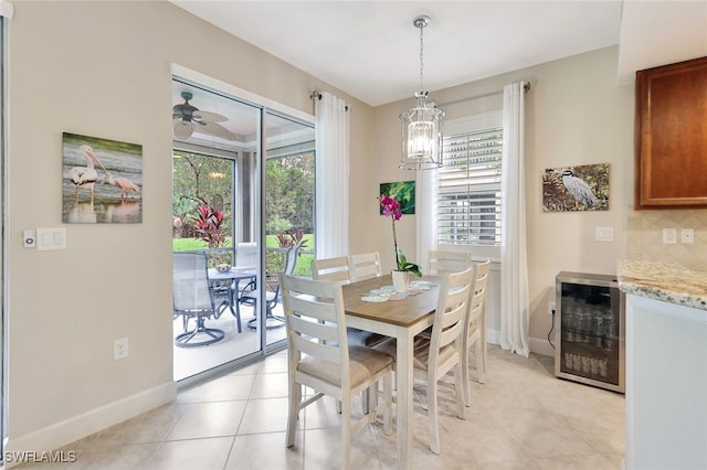 tiled dining area with wine cooler, a healthy amount of sunlight, and ceiling fan with notable chandelier