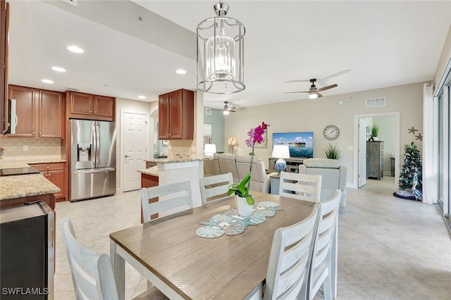 dining space featuring light tile patterned floors, ceiling fan with notable chandelier, and beverage cooler