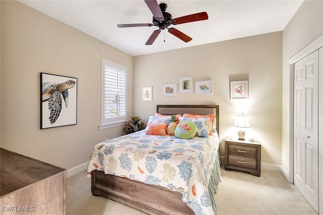 carpeted bedroom featuring ceiling fan and a closet